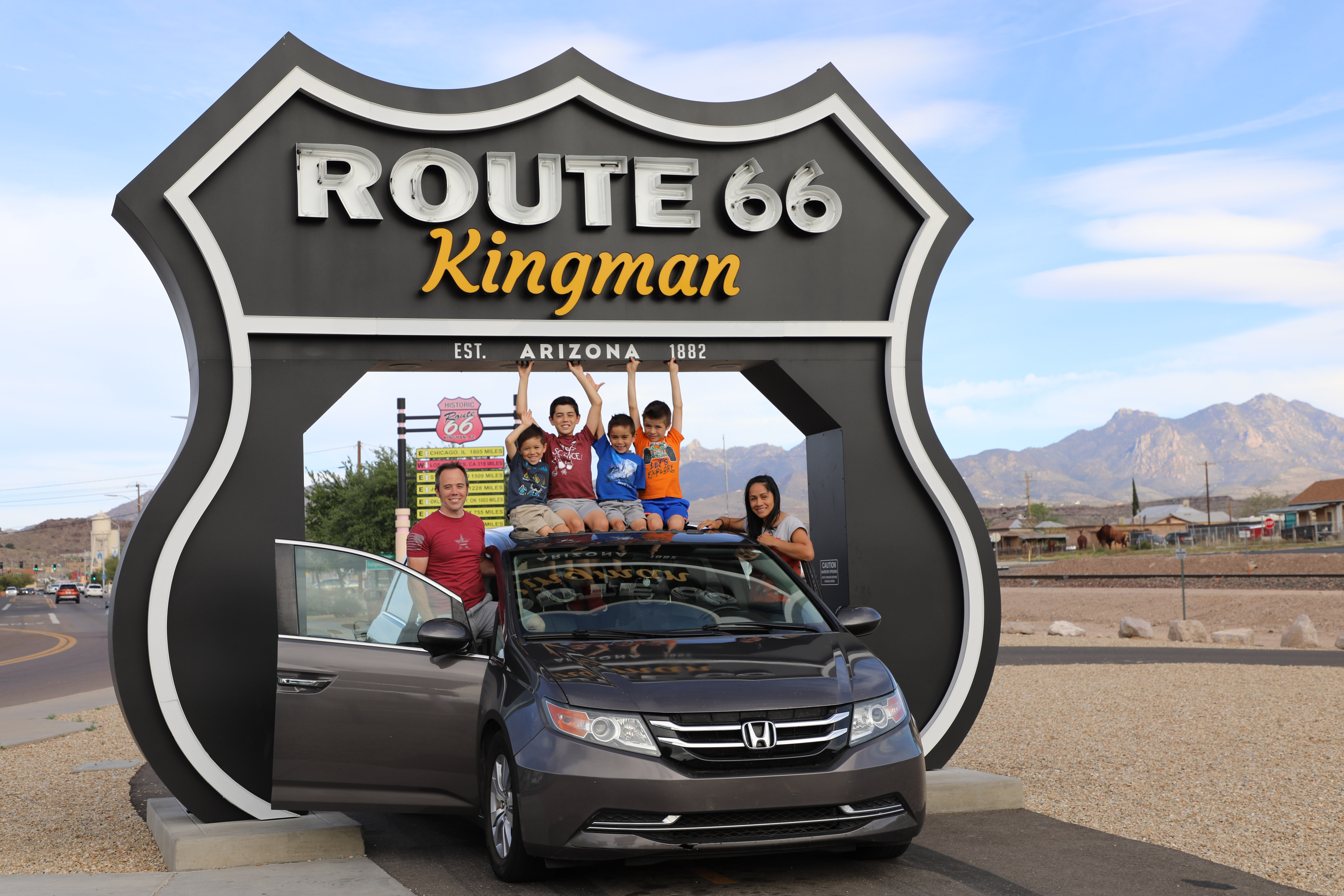 A family posing at the Route 66 Drive-Thru Shield in Kingman, Arizona A family posing at the Route 66 Drive-Thru Shield in Kingman, Arizona