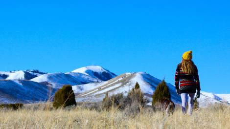 Hiking among sage, grasses and junipers toward snow-covered peaks