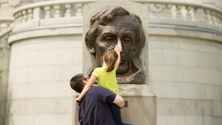 Rubbing the nose of the Abraham Lincoln bust for good luck at his tomb in Springfield, Illinois