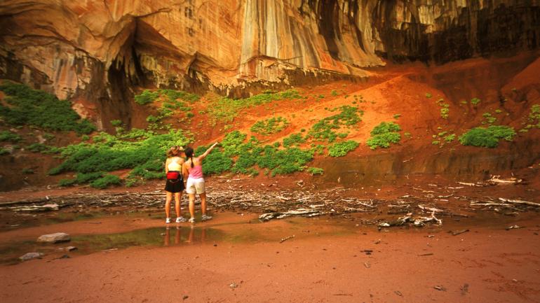 健行者欣賞科隆布峽谷的雙拱門洞