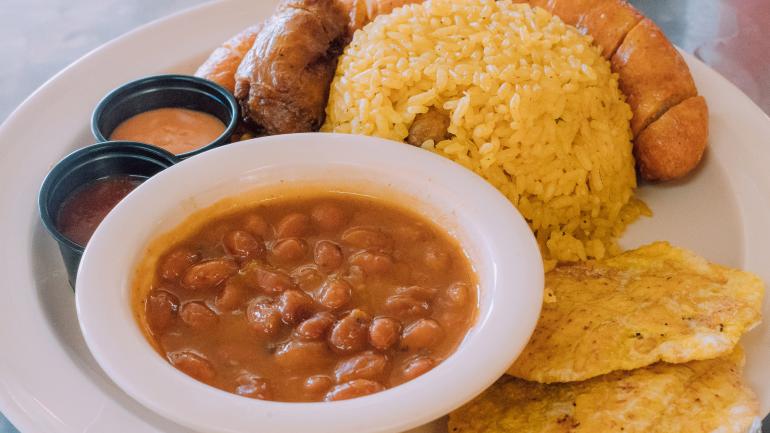 토스토네스(튀긴 플랜테인), 콩과 밥을 곁들인 전통 롱가니사 소시지