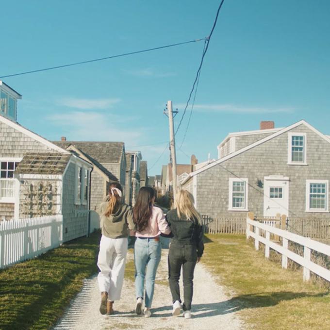 Friends walking along a charming coastal pathway in Massachusetts Friends walking along a charming coastal pathway in Massachusetts