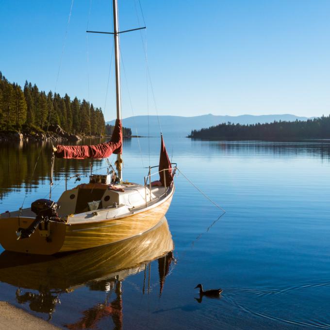 A lone sailboat waits at the edge of the lake 