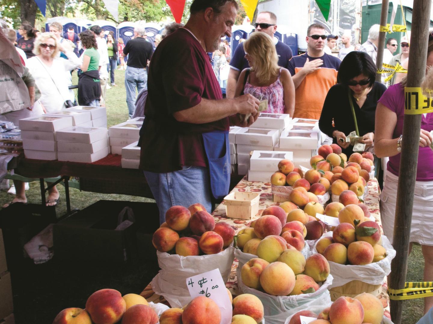 Un granjero vendiendo sus duraznos frescos en el Niagara County Peach Festival anual