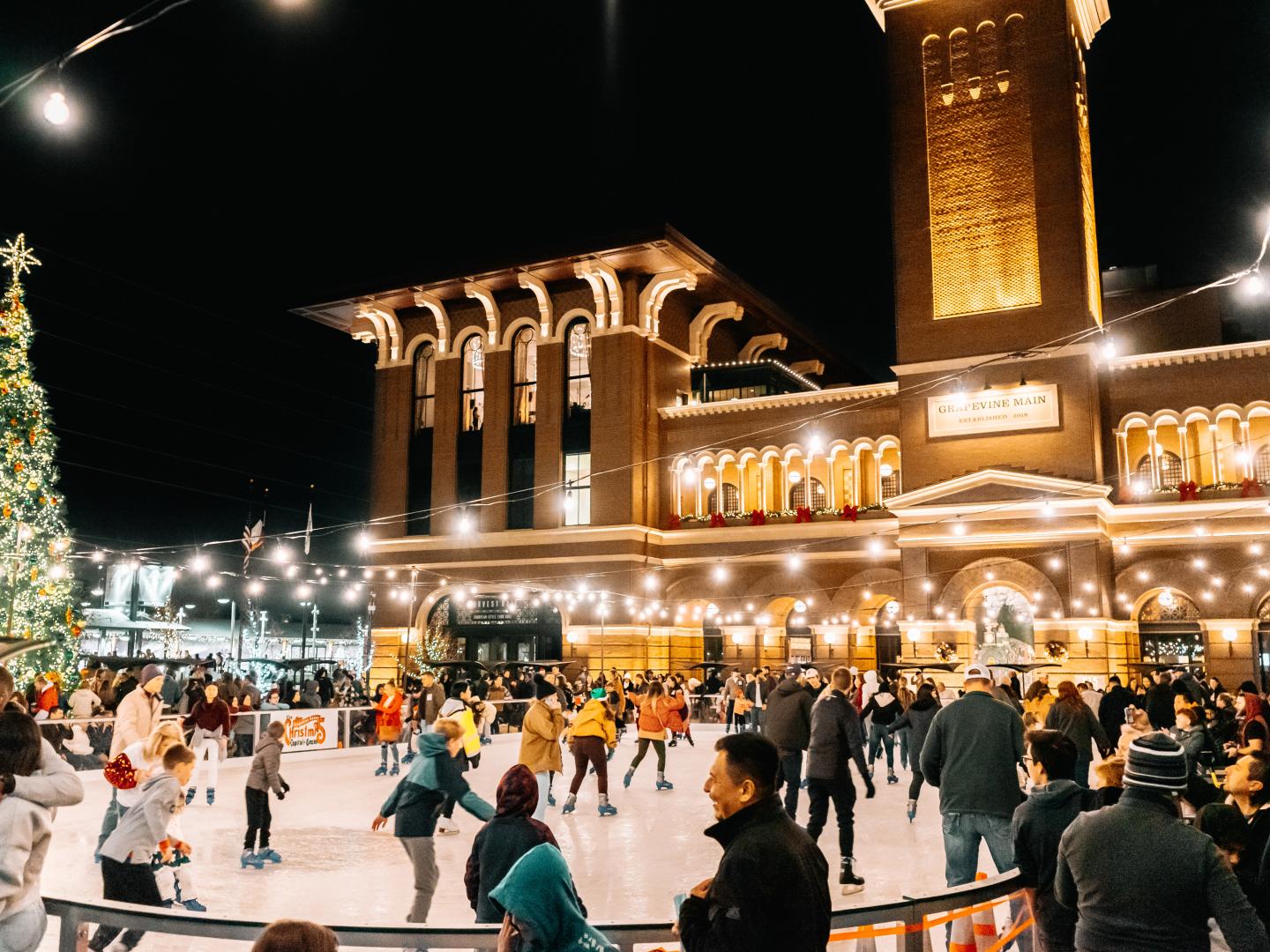 Patinadores no gelo apreciam decorações de Natal durante o evento Christmas Capital of Texas em Grapevine, Texas