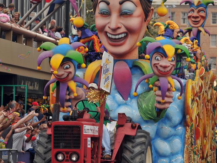 A colorful Mardi Gras float parades through the street