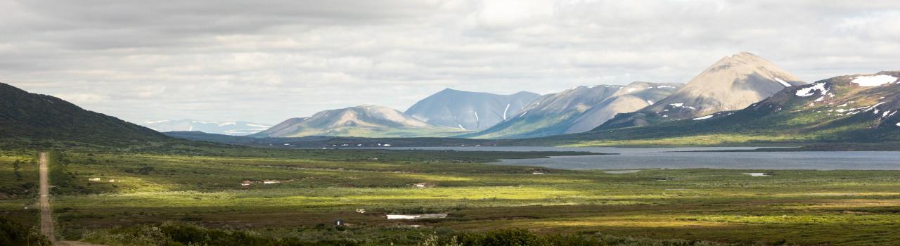 Mountain peaks line a dirt road outside Nome