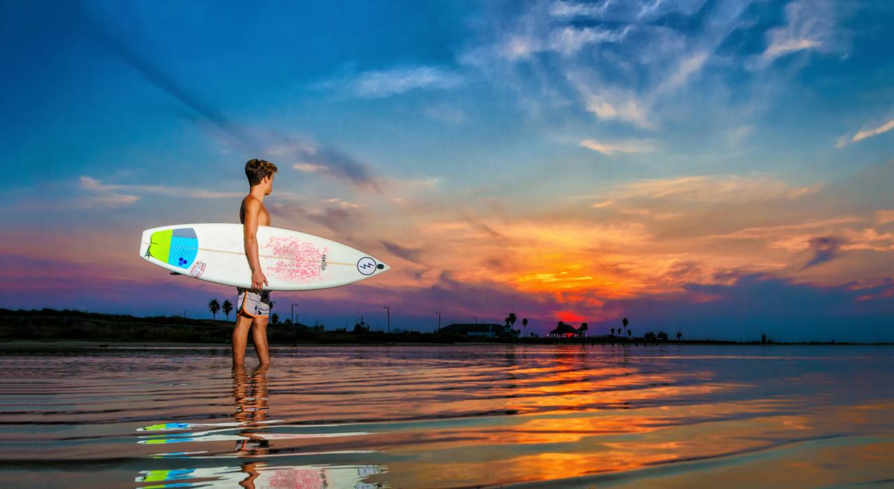 在德克萨斯州布拉佐斯波特的日出时分冲浪