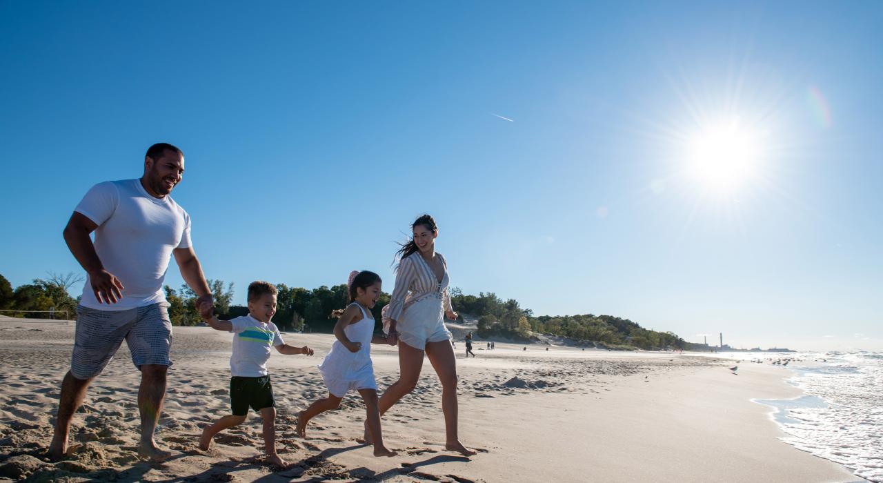 Family running on the beach in the Indiana Dunes region