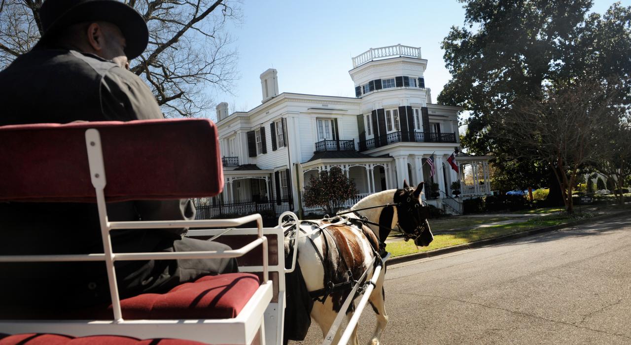 A horse and buggy rolls past a stately home in one of Columbus’s historic neighborhoods