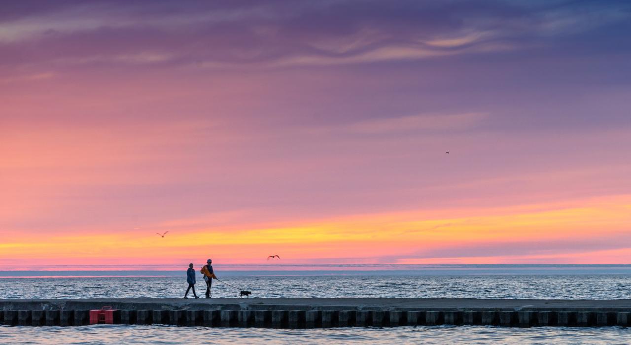 Couple marchant le long d’une jetée au soleil couchant à Grand Haven, Michigan