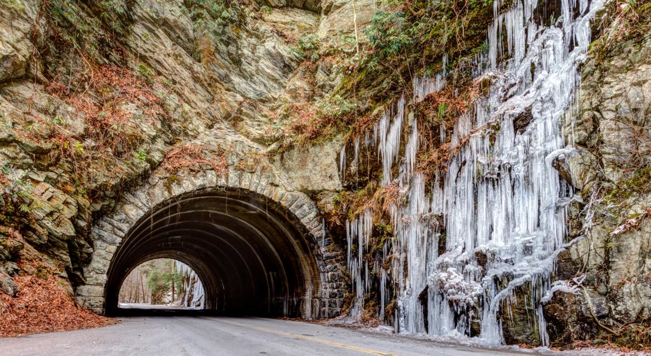 Frozen waterfall at the entrance of a mountain tunnel