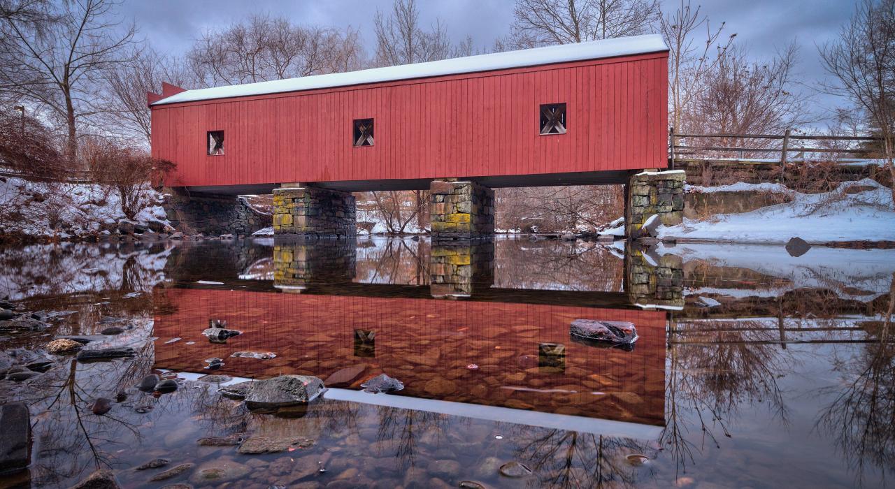 지붕 덮인 다리를 고스란히 비추는 고요한 밀 강