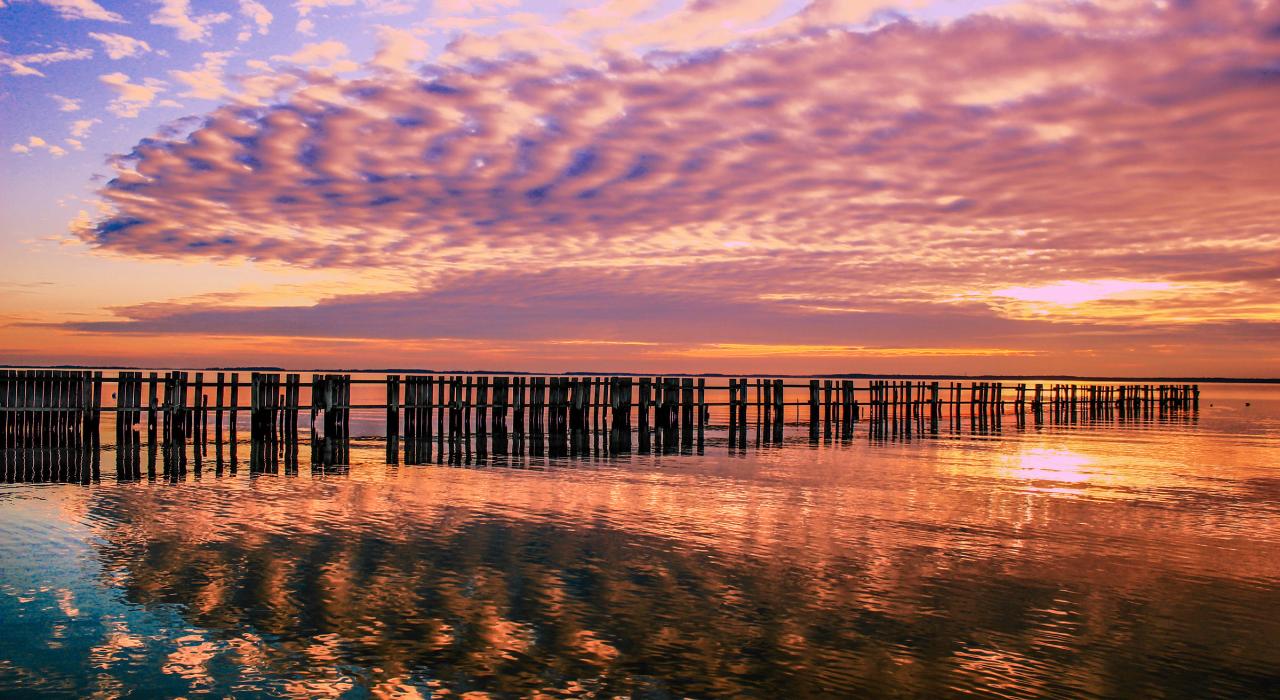 Multicolored sky reflecting in the water on a fall evening