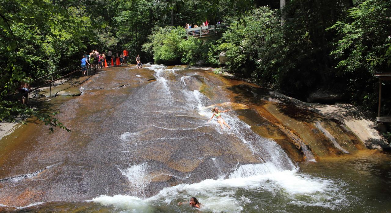 Swimmers sliding down the smooth-surfaced Sliding Rock boulder in Pisgah National Forest