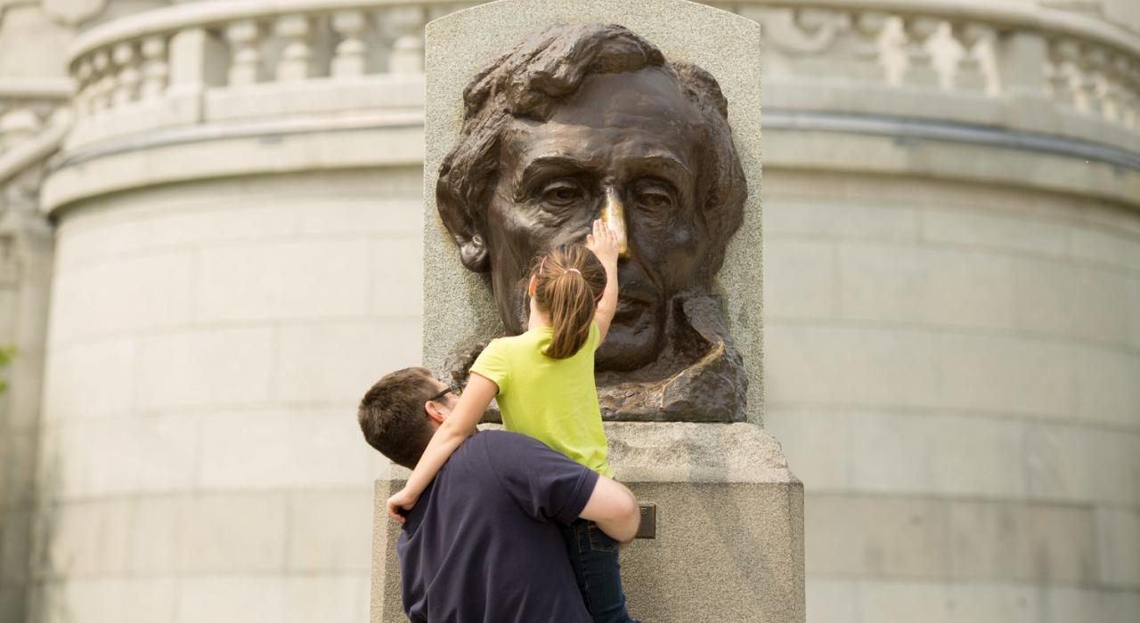 Rubbing the nose of the Abraham Lincoln bust for good luck at his tomb in Springfield, Illinois