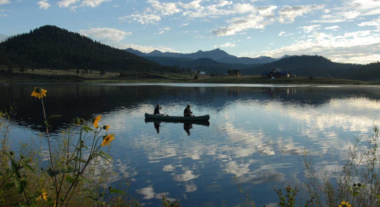 コロラド州南西部の山あいの湖でカヌーを漕ぐ人
