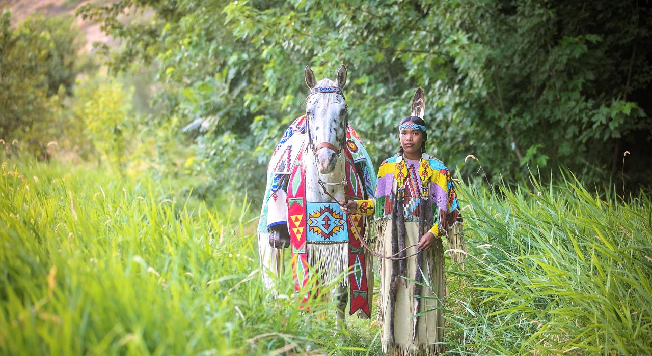 A Nez Perce guide leading an Appaloosa horse in Spalding